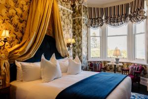 a bedroom with a bed with a blue and yellow curtain at Hulbert House Luxury Boutique Lodge Queenstown in Queenstown
