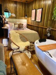 ein Schlafzimmer mit Bett und Badewanne neben einem Boot in der Unterkunft Casa das Palmeiras in Orleans