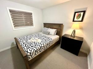 a bedroom with a bed with a lamp and a window at Escape to Niagara 6 bedrooms, 5 baths with a game room, arcades in Thorold