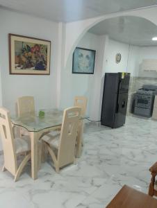 a dining room with a table and chairs and a refrigerator at Apartamento Central in Pereira +2 photos