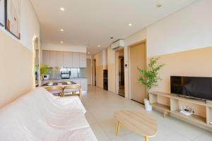 Una sala de estar con un sofá, un televisor y una mesa. en The Song Premium Apartment, en Vung Tau