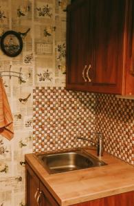 a kitchen with a sink and a tiled wall at Karja Apartment Narva-Jõesuu in Narva-Jõesuu +25 photos