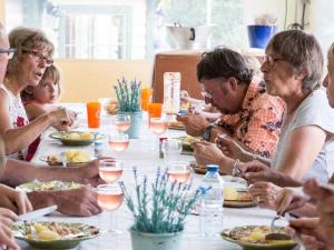 eine Gruppe von Menschen sitzt um einen Tisch herum und isst in der Unterkunft Mobil home moderne avec terrasse - 6 pers. - API-1-52-431 in Crissé