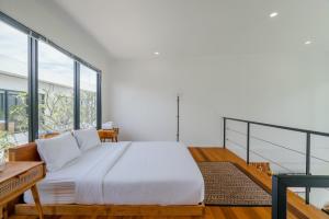 ein Schlafzimmer mit einem Bett und einem großen Fenster in der Unterkunft Canggu 2Plex Apartment in Canggu + 47 Fotos