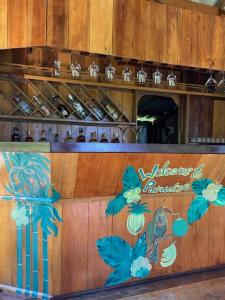 a bar with a wooden wall with flowers on it at Lily's Blue View in Koh Rong Island +30 photos