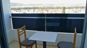 a white table and two chairs in front of a window at City Center Residency With Panoramic City Views - 2 Min Train Station by ZenStay in Fès