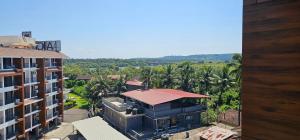 an aerial view of a building with palm trees at Elegant 1BHK Couples Getaway with River View, Pool, Gym, Amenities - Near Candolim Beach in Candolim