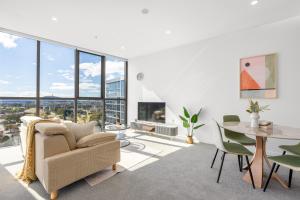 a living room with a couch and a table and chairs at Sunny Central Woden Apt,Hospital, CIT , Pool in Phillip