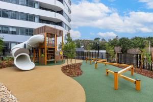 a playground with a slide in front of a building at Sunny Central Woden Apt,Hospital, CIT , Pool in Phillip