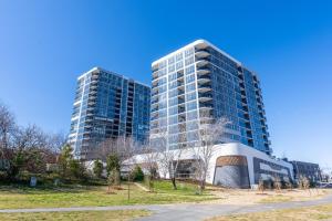 two tall buildings in a city with a park at Sunny Central Woden Apt,Hospital, CIT , Pool in Phillip