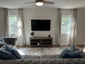 a living room with a couch and a flat screen tv at CASA SOLÉ, South Tampa in Tampa