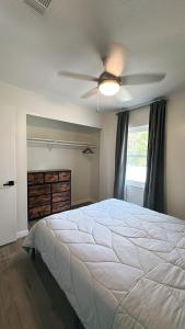 a bedroom with a white bed and a ceiling fan at CASA SOLÉ, South Tampa in Tampa