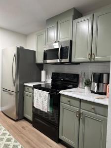 a kitchen with stainless steel appliances and white cabinets at CASA SOLÉ, South Tampa in Tampa