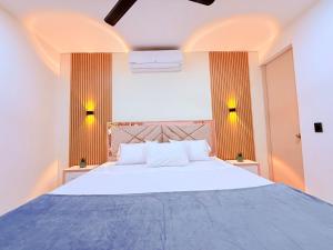 a bedroom with a large white bed with two tables at Villa Santy Paraiso lujoso & Privado in Ricaurte +45 photos