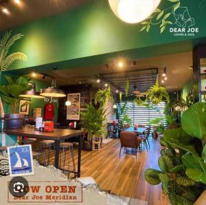 a restaurant with a table and chairs and plants at Serene Suites Condo unit in Bacoor