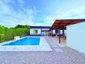 a villa with a swimming pool and a house at Villa Santy Paraiso lujoso & Privado in Ricaurte