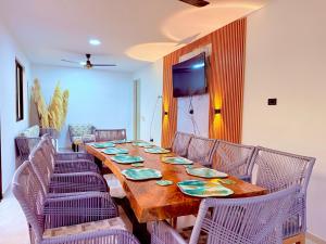 a dining room with a long wooden table and chairs at Villa Santy Paraiso lujoso & Privado in Ricaurte