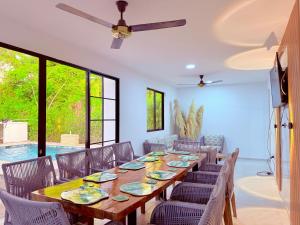 a dining room with a long table and chairs at Villa Santy Paraiso lujoso & Privado in Ricaurte