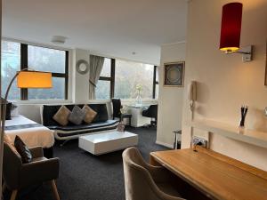 a bedroom with a bed and a living room at Paxsafe Sydney Hyde Park Private Apartments in Sydney