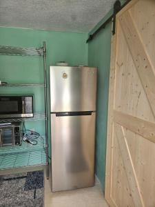 a refrigerator in a kitchen next to a door at Bed & Shower Stop in East End