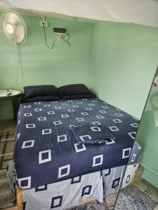 a bedroom with a bed with a blue and white comforter at Bed & Shower Stop in East End