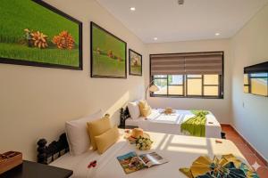 a bedroom with two beds and a couch at Du Yen Hoi An Villa in Hoi An