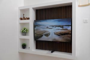 a flat screen tv on a wall in a room at Modern Guest House 2BR in Nakuru