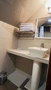 a bathroom with a sink and towels on a shelf at Avraham Hotels in Machu Picchu