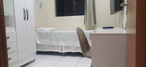 a small white room with a bed and a window at Excelente apartamento a 5 min da COP30 in Belém