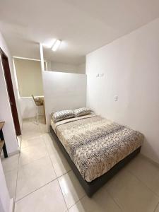 Un dormitorio con una cama en una habitación blanca. en Apartamento en Cabecera, en Bucaramanga