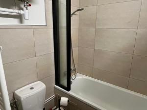 a bathroom with a tub and a toilet and a shower at Studio moderne à Super Besse, vue lac des Hermines - FR-1-814-136 in Super Besse