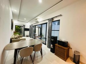 una sala de estar con una mesa y un sofá en Athalia Villa Seminyak, en Seminyak