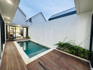 una piscina en medio de una casa en Athalia Villa Seminyak, en Seminyak 3 fotos más