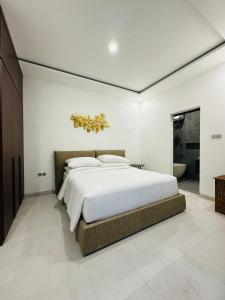 Un dormitorio con una cama grande y un baño. en Athalia Villa Seminyak, en Seminyak