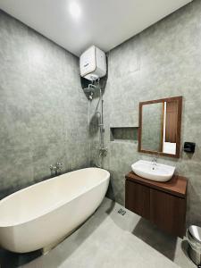 y baño con bañera blanca y lavamanos. en Athalia Villa Seminyak, en Seminyak