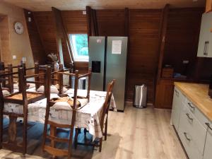 a kitchen with four tables and a refrigerator at Grand chalet moderne pour 14 pers à Super Besse - FR-1-814-150 in Super Besse +24 photos
