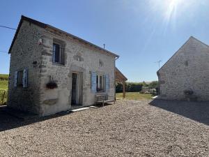 an old stone building on a gravel driveway at Gîte charmant à Bellenaves, 2 pers, animaux admis - FR-1-489-595 in Valignat
