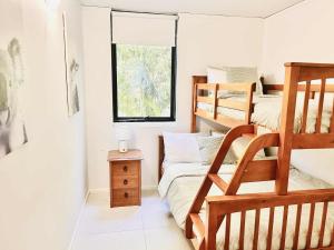 a bedroom with two bunk beds and a window at Rainbow Beach Resort overlooking Pool in Rainbow Beach +25 photos