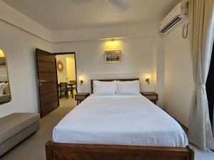a bedroom with a large white bed in a room at Rustic 1BHK Apartment, Gym, Pool, Amenities - Near Candolim Beach in Candolim +28 photos