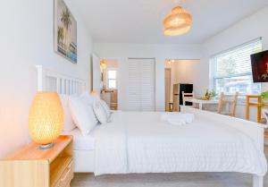 a white bedroom with a white bed and a table at Casa Agave Miami in Miami