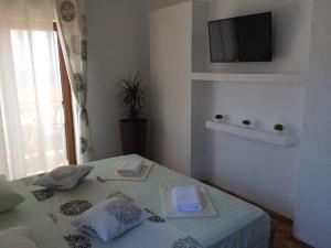 a bedroom with a bed with a television on the wall at Apartments Debora in Ulcinj