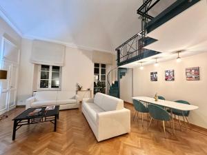 a living room with white furniture and a table at La casa di famiglia - elegante immobile di prestigio in centro in Turin