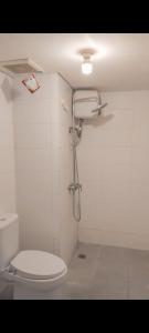 a bathroom with a toilet and a shower at Appartemen candiland in Jomblang