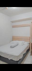 a bed with white sheets and pillows in a room at Appartemen candiland in Jomblang