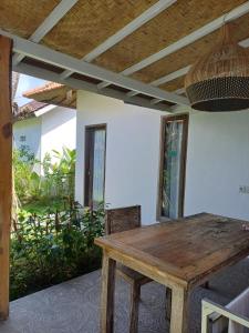 Una mesa y sillas de madera en una habitación. en Green Bowl Bali Guest house, en Ungasan