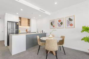 a kitchen with a table and chairs in a room at Cozy Woden Stay, Hospital, Mall, Pool, Parking in Phillip