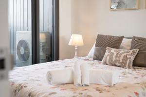 a bed with white blankets and pillows and a fan at Cozy Woden Stay, Hospital, Mall, Pool, Parking in Phillip +21 photos