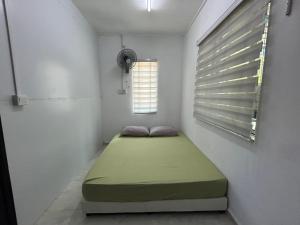 にあるThe Orbit Retreatの窓のある部屋に緑色のベッドが置かれた小さな寝室