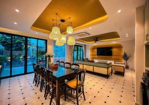 a dining room with a table and chairs and a couch at Hometown Signature Retreat Villa Hoi An in An Bang