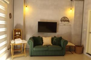 a living room with a green couch and a tv at 無名藝境 in Sanxing